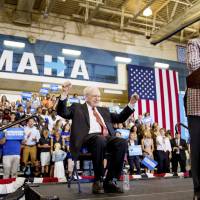 Democratic presidential candidate Hillary Clinton, accompanied by Berkshire Hathaway Chairman and CEO Warren Buffett, pauses while speaking at a rally at Omaha North High Magnet School in Omaha, Nebraska, Monday. Trump blasts Buffett's rebuke over his business credentials