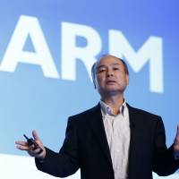 SoftBank CEO Masayoshi Son speaks in front of a screen displaying the ARM Holdings Plc logo at a Tokyo news conference on July 28. Bank trio arranging ¥1 trillion syndicated loan for SoftBank's acquisition of ARM