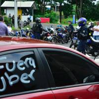 Taxi drivers block a road in San Jose Tuesday. Thousands of taxi drivers upset at Uber's threat to their livelihoods blocked key roads in and near Costa Rica's capital, with dozens arrested amid clashes with police, officials said. Costa Rica cabbies clash with cops amid protest over Uber market surge