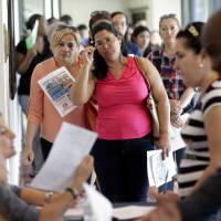 A woman stands in line at a job fair in Miami Lakes, Florida, on July 19. More Americans starting to reap benefits after period of steady hiring