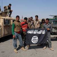 Afghan police pose for a photograph with an Islamic State flag after an operation in the Kot district of Jalalabad province east of Kabul on Aug. 1. Islamic State faces uphill 'branding war' in Afghanistan, Pakistan