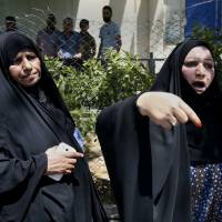 Families of newborn babies who died in a fire gather outside a maternity ward at Yarmouk Hospital in western Baghdad Wednesday. Baghdad maternity ward blaze kills 12 newborns; Iraq health chief exits