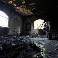 A Libyan man investigates the inside of the U.S. Consulate in Benghazi, Libya, after a deadly attack two days earlier in 2012. The State Department says about 30 emails that may be related to the 2012 attack on U.S. compounds in Benghazi are among the thousands of Hillary Clinton emails recovered during the FBI's recently closed investigation into her use of a private server. Benghazi emails involving Clinton among those recovered by FBI