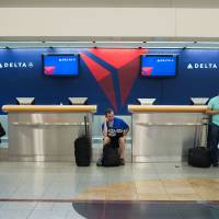 Passengers wait at Hartsfield-Jackson Atlanta International Airport on Aug. 8 after Delta flight cancellations and delays moved into their fourth day. More airline travel disruptions likely as carriers grapple with aging technology