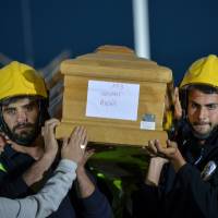 Italian Civil Defence (Protezione Civile) volunteers carry a coffin during a funeral service for victims of the recent earthquake in a tent complex in Amatrice, central Italy, on Tuesday. Bishop hits at shoddy quake-proofing as Italy buries dead from temblor