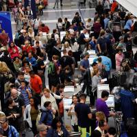 Delayed passengers inside Terminal 7 at Los Angeles International Airport line up to go through TSA security check following a false alarm event in Los Angeles Sunday. Mass panic at LAX amid false reports of shots fired as cops nab man clad as Zorro