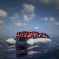 About 150 sub-Saharan refugees and migrants wait Thursday aboard an overcrowded rubber boat to be assisted by an NGO during a rescue operation on the Mediterranean Sea off Lybia. Over 6,500 migrants rescued off Libya since Thursday, Italy says