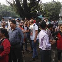 People stand outside their offices after they rushed outdoors following tremors in Kolkata, India, on Aug. 24, 2016. Officials say a powerful earthquake has shaken central Myanmar and neighboring countries. Powerful quake hits Myanmar, damaging famed Bagan temples