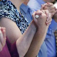 Family members of Sister Paula Merrill hold hands during the saying of the Lord's Prayer during a memorial Mass for Merrill and Sister Margaret Held, Monday at the Cathedral of St. Peter the Apostle in Jackson, Mississippi. The two nuns were killed Thursday in their Durant home, and authorities continue to investigate the stabbing. Hundreds of people filled a cathedral in Jackson on Monday to remember two nuns who spent decades helping the needy. Slain nuns who nursed Mississippi's poor remembered for 'Christian love in action'