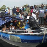 Cuban and Haitian migrants board a vessel to Capurgana, in the Caribbean Gulf of Uraba in northwestern Colombia, to illegally cross to Panama through the jungle, on Saturday. Hundreds of Cubans stranded in northwest Colombia have been left facing deportation after the government adopted emergency measures against illegal migration following a massive U.S.-bound influx. Panama to help hundreds of U.S.-bound migrants head north after jungle trek