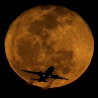 A waning moon rises in the distance as a passenger jet takes off at Phoenix's Sky Harbor Airport in 2013. A handful of U.S. pilots each year fail random sobriety tests. Those who fail can fly again if they prove rehabilitation. Drunk pilots extremely rare but make headlines, have also rehab recourse