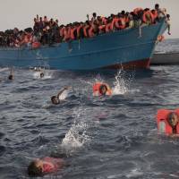 Migrants, most of them from Eritrea, jump into the water from a crowded wooden boat as they are helped by members of an NGO during a rescue operation at the Mediterranean sea, about 13 miles north of Sabratha, Libya, Monday. Thousands of migrants and refugees were rescued Monday morning from more than 20 boats by members of Proactiva Open Arms NGO before transferring them to the Italian cost guard and other NGO vessels operating in the zone. Thousands of migrants rescued in day off Libya by European vessels