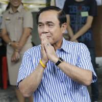 Thai Prime Minister Prayuth Chan-ocha gestures as he leaves a polling station in Bangkok on Sunday after casting his vote in a referendum on a new constitution. Thai voters overwhelmingly approve junta-backed constitution