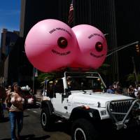People take part in the GoTopless Pride Parade on Sunday in New York. Women across U.S. bare breasts for gender equality on GoTopless Day