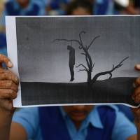An Indian schoolgirl holds an image of a hanged man during a rally in Ahmedabad in December 2012 after the victim of a brutal New Delhi gang-rape died. U.N. program aims to collect data on domestic violence in Asia-Pacific region