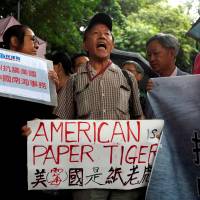 A protester from a local pro-China party chants slogans against the United States' backing of an international court ruling that denied China's claims to the South China Sea, outside U.S. Consulate in Hong Kong on July 14. Emboldened Chinese military presses Xi for stern response to South China Sea ruling