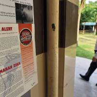 A Zika alert notice is seen posted at the lift landing area of a residential block in the Aljunied Crescent neighborhood in Singapore on Monday. Zika spreads in Singapore as U.S. firm tests vaccine in Puerto Rico, virus seen in mosquito eggs