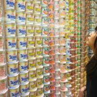 A visitor looks at a wall of instant noodles on display at the Cup Noodles Museum in Yokohama on Aug. 15. Cup Noodles slurping strong, 45 years on