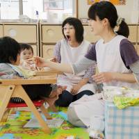 Staff feed children at a nursery in the city of Akita. The government plans to offer tax cuts to landowners so more properties will be leased to build nurseries and kindergartens. Tax breaks mulled for landowners who lease to nurseries and preschools