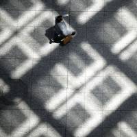 A business man walks through a building in Tokyo. Some businesses are using the internet to interview college students in rural areas or abroad. Japan Inc. hiring grads via online interviews