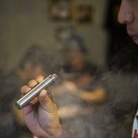 A customer holds a vaporizer at the Vaping Ape store in Shibuya. They sell e-juice for vaping, but are unable to sell liquid containing nicotine. Japan Tobacco playing catchup as nation takes to vaping in big way