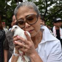 The hardest month: A woman prepares to release a dove at Yasukuni Shrine in Tokyo on Monday, on the 71st anniversary of Japan's World War II surrender. In Japan, August is for remembering