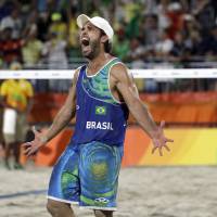 Brazil’s Bruno Oscar Schmidt celebrates after beating the Netherlands during a men’s beach volleyball semifinal match at the Rio Olympics on Tuesday in Rio de Janeiro. Born into hoops, this Schmidt has sand in his soul