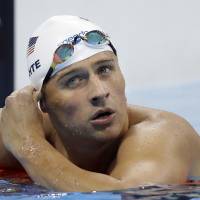Ryan Lochte checks his time Aug. 9 in a men's 4x200-meter freestyle heat during the swimming competitions at the 2016 Summer Olympics, in Rio de Janeiro. Lochte and three other American swimmers were allegedly robbed at gunpoint early Sunday by thieves posing as police officers who stopped their taxi and took their money and belongings, the U.S. Olympic Committee said. Lochte back home before Rio judge ordered him to stay put but two other U.S. swimmers taken off plane: reports
