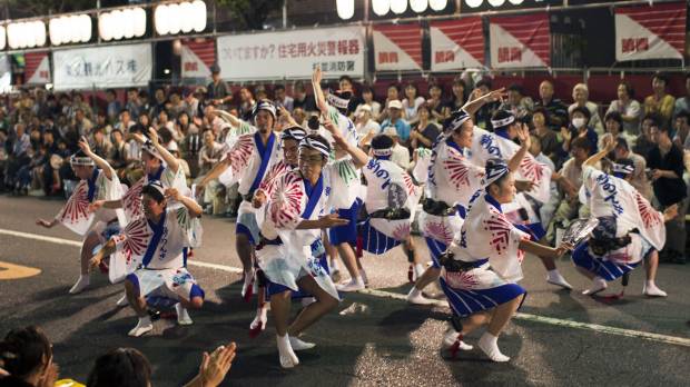 Block party: The Shin-Nonki troupe of dancers entertain a crowd on the street near Koenji Station in Tokyo. Koenji's Awa Odori festival celebrates 60 years