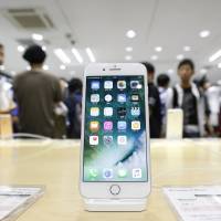 An iPhone 7 Plus is displayed at a SoftBank store in Tokyo on Sept. 16. FTC puts Apple, Japanese carriers in antitrust cross hairs