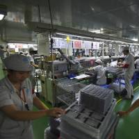 Workers assemble smartphones at a factory in Guang'an, Sichuan province. Group of 20 leaders who will meet on Sunday in Hangzhou, China, say more trade would help shore up sluggish global growth but are tightening import controls at the same time. G-20 nations endorse global trade but tighten import controls
