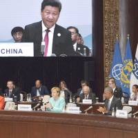 Leaders of the Group of 20 countries hold a session on the first day of weekend talks that ended Monday in Hangzhou, China, as host Xi Jinping is shown on the screen. G-20 leaders join hands against protectionism