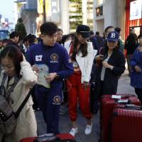 Chinese tourists board a tour bus in the Ginza district of Tokyo in April. Tokyo Metro to launch left-luggage service