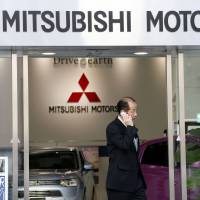 A man is seen leaving the headquarters of Mitsubishi Motors Corp. in Tokyo in this February 2013 file photo. Transport ministry officials raided the head office of the scandal-ridden company on Friday. Transport Ministry raids Mitsubishi Motors headquarters over mileage-cheating scandal
