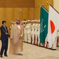 Prime Minister Shinzo Abe escorts visiting Saudi Arabia's Deputy Crown Prince Mohammed bin Salman as they review a guard of honor prior to their meeting at Abe's office in Tokyo on Thursday. Abe, Saudi prince vow cooperation on economic plan