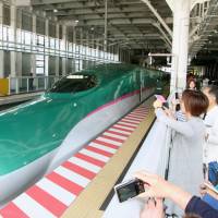 Fans snap photos of a Hokkaido Shinkansen train at Shin-Hakodate-Hokuto Station in Hokkaido in May. Mixed results for land prices on new shinkansen routes