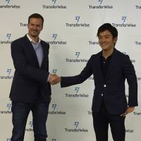 TransferWise Ltd. CEO Taavet Hinrikus (left) shakes hand with Kazuma Ochi, who heads the Japan office, during a news conference Sept. 7 in Tokyo. U.K. startup looks for a slice of Japan's remittance market