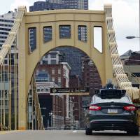 A self driving Uber car drives across the ninth street bridge in downtown Pittsburgh Wednesday, when a fleet of self-driving Ford Fusions began picking up Uber riders who opted to participate in a test program. Uber hopes if driverless taxis make it in Pittsburgh, they can make it anywhere