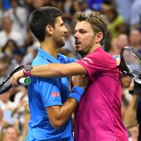 Stan Wawrinka of Switzerland, wearing a Yonex shirt, hugs Serbia’s Novak Djokovic, wearing a Uniqlo shirt, after the men’s singles final on day fourteen of the 2016 U.S. Open tennis tournament in New York on Sunday. At U.S. Open, Japanese brands leave Nike, Adidas in the dust