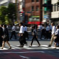 Pedestrians cross a road in Tokyo. Average private sector pay inched up to ¥4,204,000 in 2015. Japan Inc. paying more, but low wages for temporary staff underscore two-track jobs sector