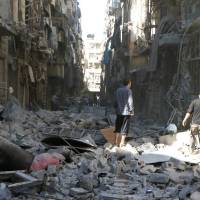 Syrians inspect buildings damaged by government airstrikes in Aleppo on Saturday in this photo provided by the White Helmets civil defense group. Syrian troops advance in Aleppo amid war's heaviest bombing