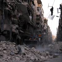 Civil Defense members work at a site hit by an airstrike in the rebel-held al-Shaar neighborhood of Aleppo, Syria, Tuesday. As Russian bombs rain down, Syria army retakes central Aleppo district