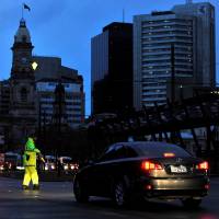 Police direct traffic in the central business district of Adelaide after severe storms knocked out power to the entire state of South Australia on Wednesday. Aussie government presses to slow switch to clean energy in wake of South Australia blackout