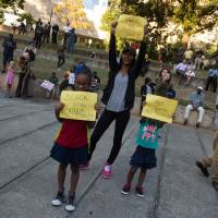 Children hold up signs during a demonstration against police brutality in Charlotte, North Carolina, on Wednesday, following the shooting of Keith Lamont Scott the previous day. Charlotte workers asked to stay home after night of violence