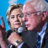 Democratic presidential nominee Hillary Clinton listens as Sen. Bernie Sanders peaks during an event at University of New Hampshire Wednesday in Durham, New Hampshire. Ex-rival Sanders, Obama urge young to back Clinton, say third-party vote favors Trump