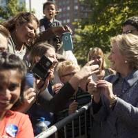 Democratic presidential candidate Hillary Clinton greets attendees during a campaign stop in Des Moines, Thursday. Clinton urges Iowans to vote early, faces third-party spoiler threat by millennials still warm to Sanders