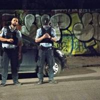 Policemen secure the area after a shooting in Freetown Christiania, Copenhagen, Thursday. Danish police say no proof gunman who shot cops during drug raid was ordered by Islamic State