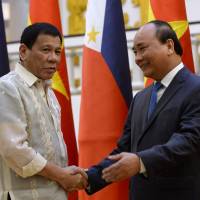 Philippines' President Rodrigo Duterte (left) shakes hands with Vietnamese Prime Minister Nguyen Xuan Phuc as they meet at Phuc's Cabinet Office in Hanoi on Thursday. Philippines' President Duterte to scrap war games with U.S.