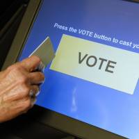 An official demonstrates a touch-screen voting machine at the Fairfax County Governmental Center in Fairfax, Virginia. Despite flaws, paperless voting machines remain widespread in U.S.