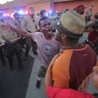 Protesters face off with police as others try to block them during a rally in El Cajon, a suburb of San Diego, Wednesday, in response to the police shooting the night before. Protesters marched in a California town following the fatal police shooting of an unarmed black man said to be mentally ill, as local officials urged calm and pledged a full investigation. Questions swirl over police killing of refugee who twice faced deportation for crimes